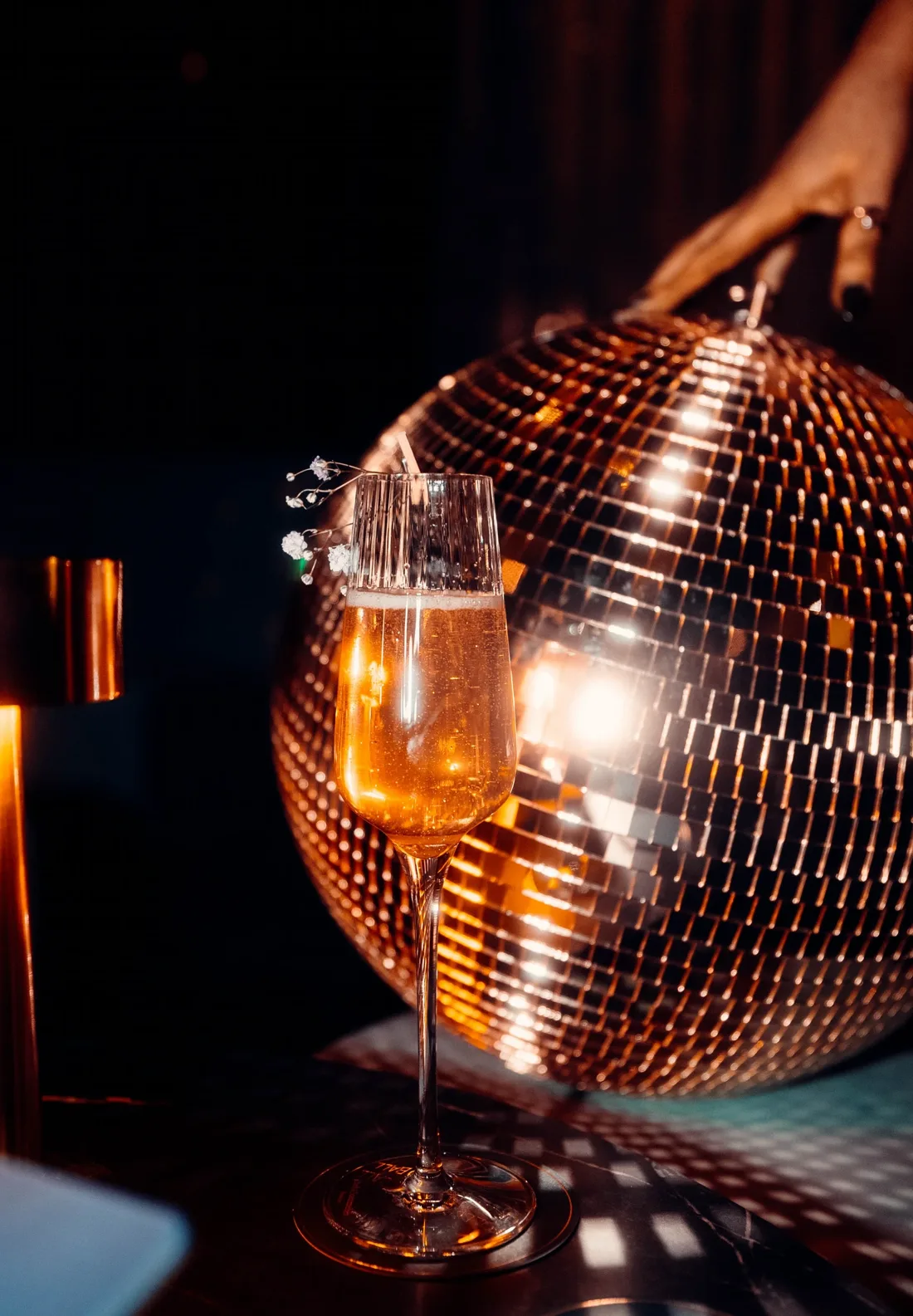 Champagne flute in front of a copper mirror ball