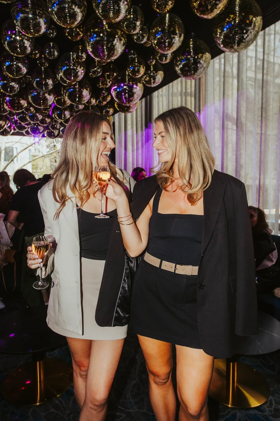 Two guests sharing a toast under the mirror-ball ceiling