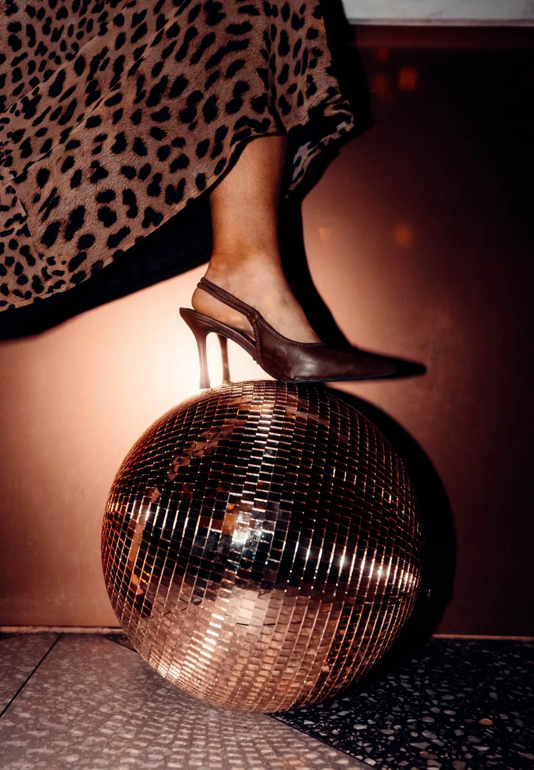 Heel resting on a rose-gold mirror ball